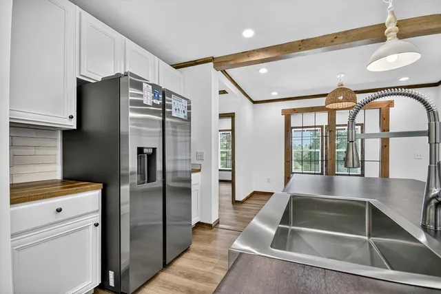 a kitchen with stainless steel appliances granite countertop a refrigerator and a sink
