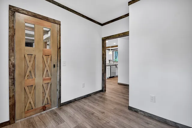 an entryway with a door and wooden floor