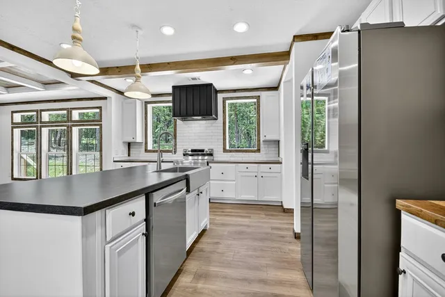 a kitchen with stainless steel appliances granite countertop a stove a sink and a refrigerator