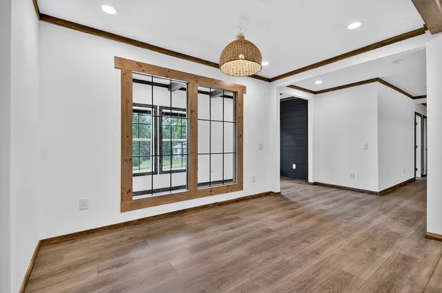 a view of a big room with wooden floor and windows