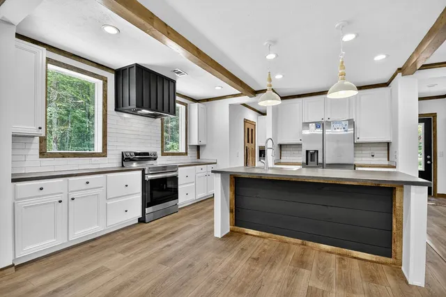 a kitchen with stainless steel appliances kitchen island granite countertop a stove and a sink