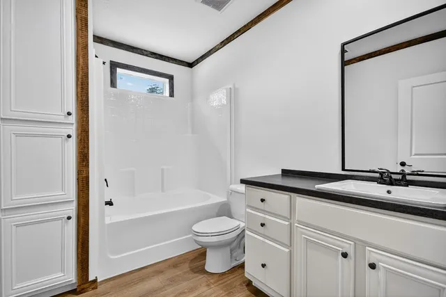 a bathroom with a granite countertop sink a toilet and a bathtub