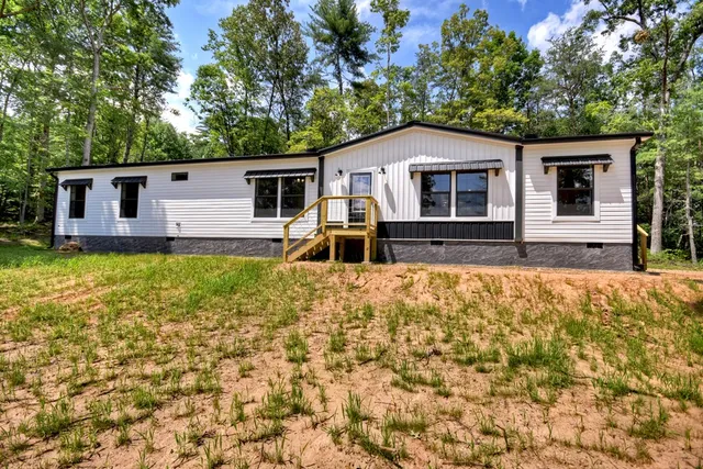 a view of an empty room with wooden floor and closet