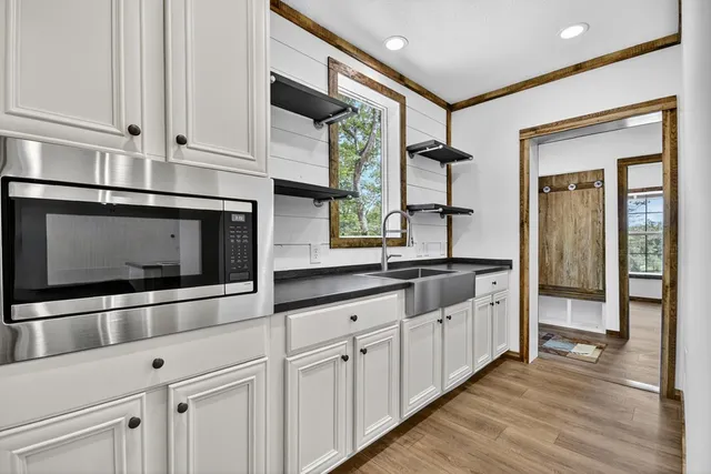 a kitchen with stainless steel appliances granite countertop a sink and a microwave