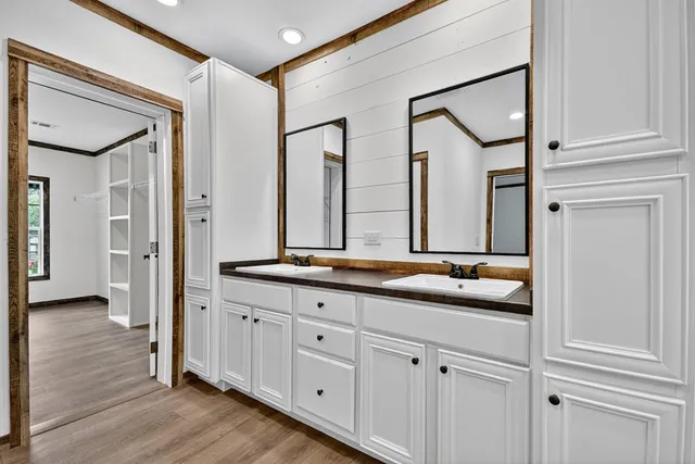 a en suite bathroom with a granite countertop sink and a mirror