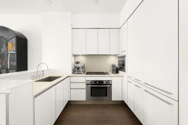 a kitchen with a sink stove top oven and cabinets
