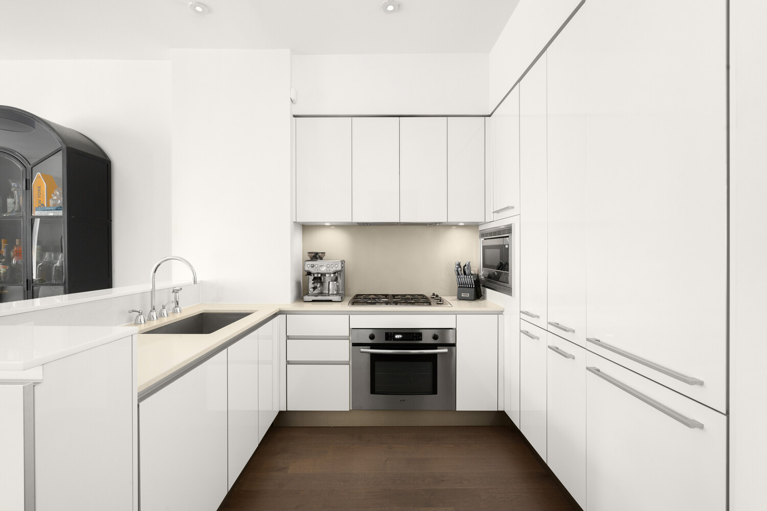 25 Broad Street, Unit 10K Manhattan, NY 10004 - Photo 3 of 12 a kitchen with a sink stove top oven and cabinets