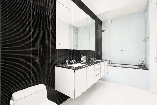 a bathroom with a sink a toilet and mirror