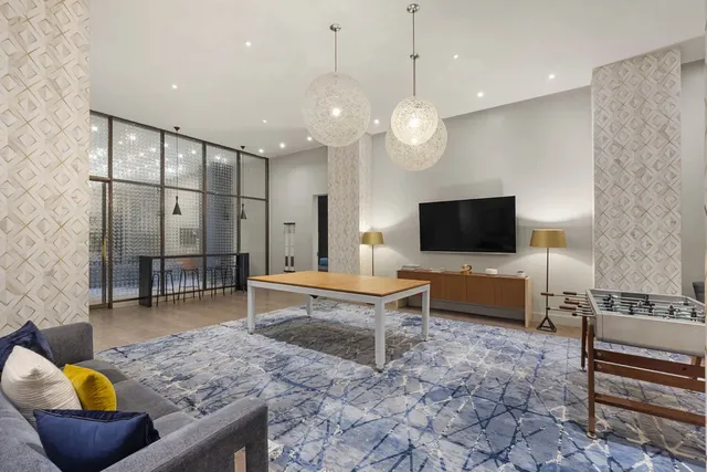 a living room with furniture a flat screen tv and kitchen view