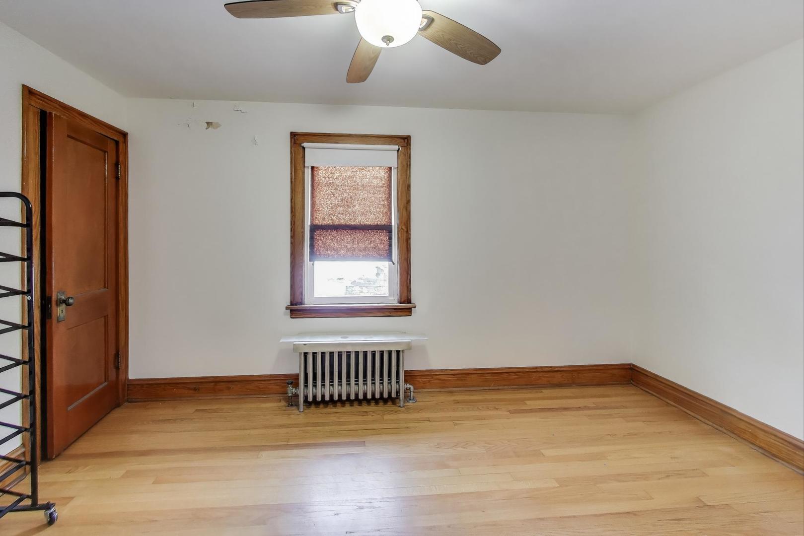 3958 South Rockwell Street Chicago, IL 60632 - Photo 23 of 38 an empty room with wooden floor chandelier fan and windows