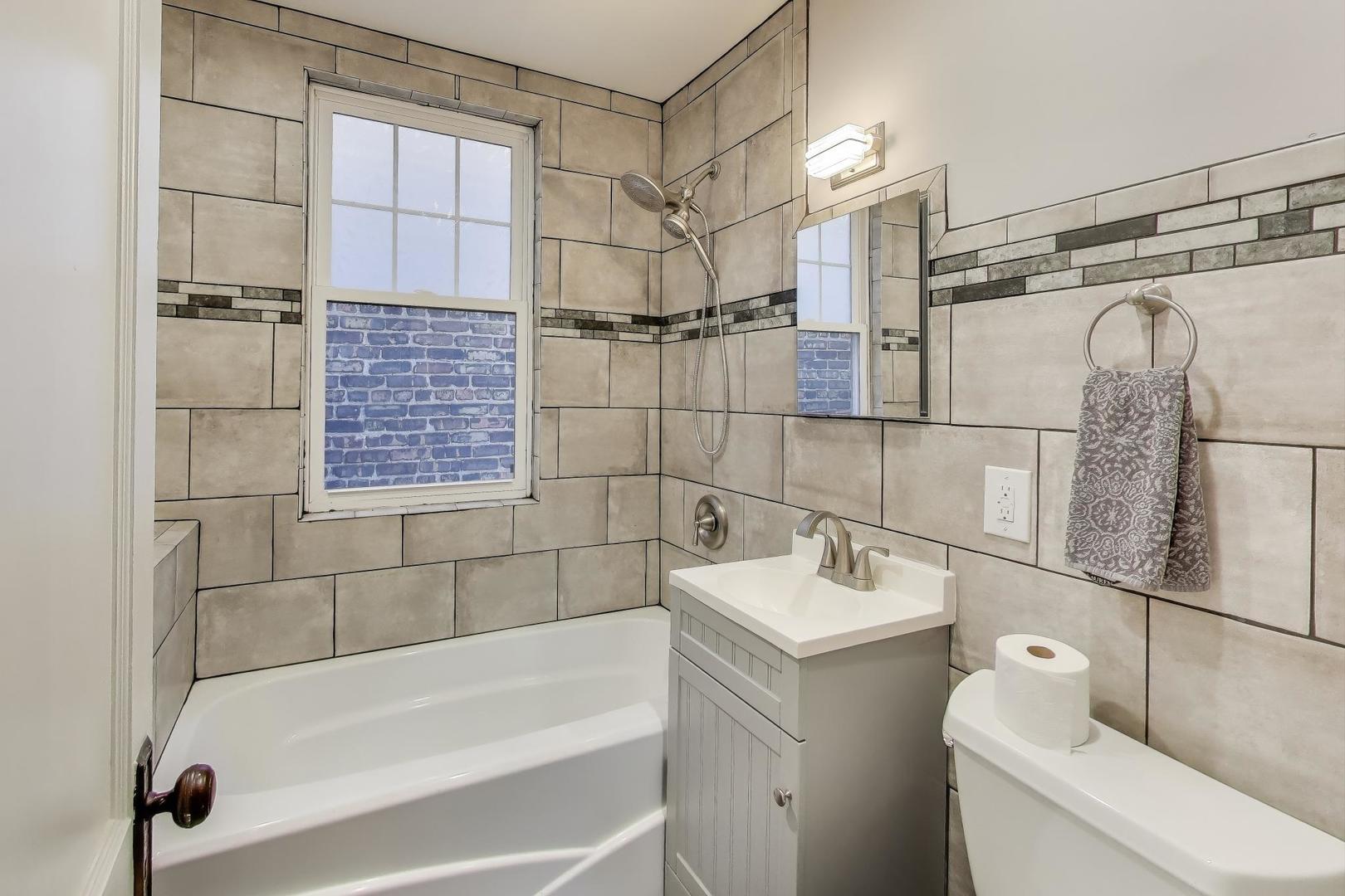 3958 South Rockwell Street Chicago, IL 60632 - Photo 27 of 38 a bathroom with a bathtub and a shower