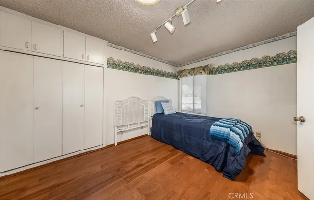 a bedroom with a bed and a refrigerator