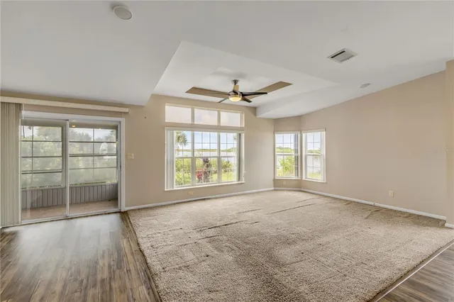 a view of a livingroom with a chandelier fan and kitchen view