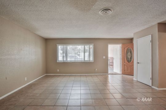 1144 West St George Avenue Ridgecrest, CA 93555 - Photo 3 of 18 a view of an empty room with window and chandelier fan