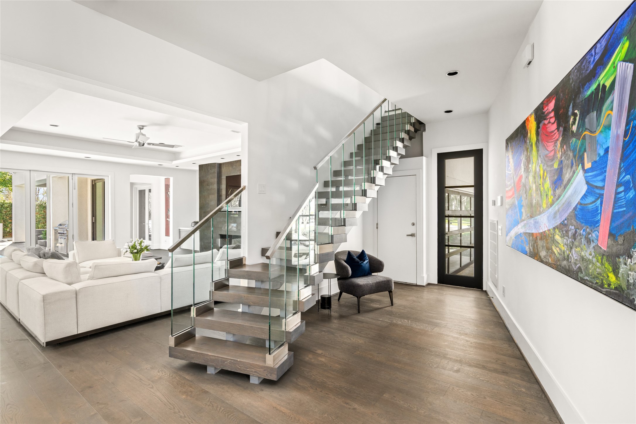 3703 Wroxton Road West University Place, TX 77005 - Photo 11 of 50 A sleek, open-concept living area with a floating staircase and glass railing.