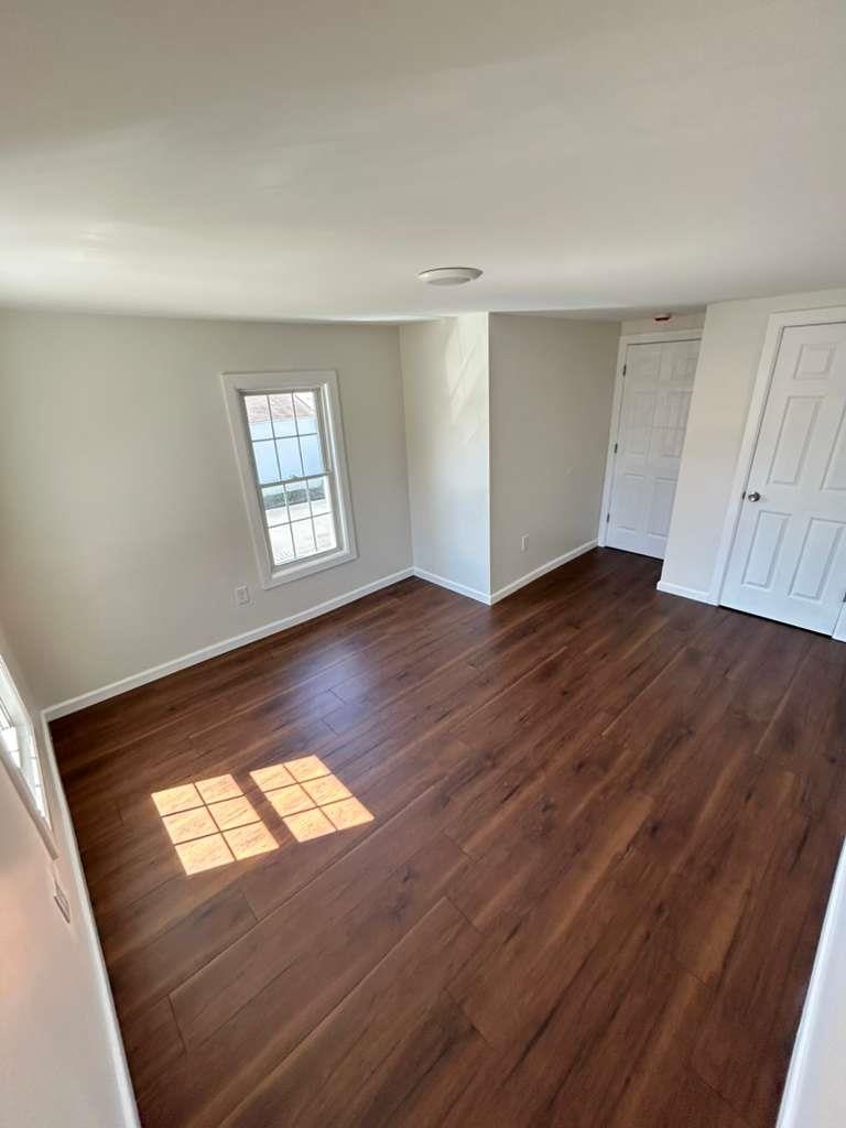 8 Hampton Street, Unit B Newton, NJ 07860 - Photo 3 of 7 an empty room with wooden floor and windows