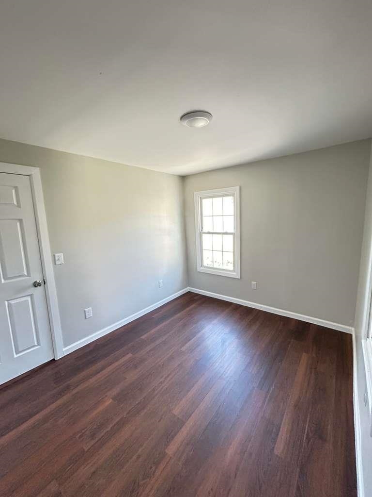 8 Hampton Street, Unit B Newton, NJ 07860 - Photo 5 of 7 an empty room with wooden floor and windows