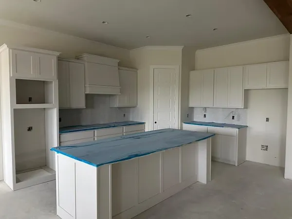a kitchen with white cabinets sink and stove