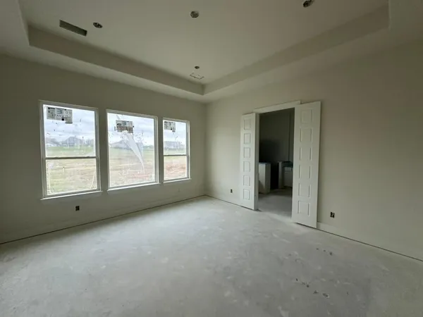 an empty room with windows and bathroom view