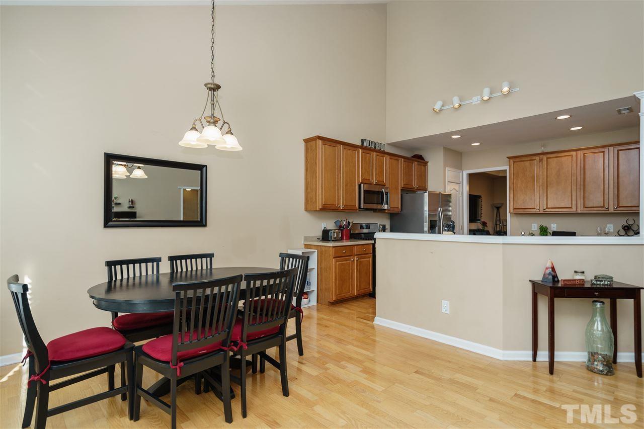 5409 Brandy Bay Road Raleigh, NC 27613 - Photo 7 of 25 a kitchen with stainless steel appliances kitchen island granite countertop a dining table chairs and a refrigerator
