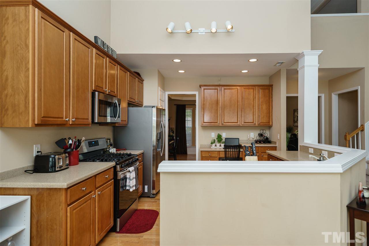 5409 Brandy Bay Road Raleigh, NC 27613 - Photo 8 of 25 a kitchen with stainless steel appliances granite countertop a sink refrigerator and cabinets