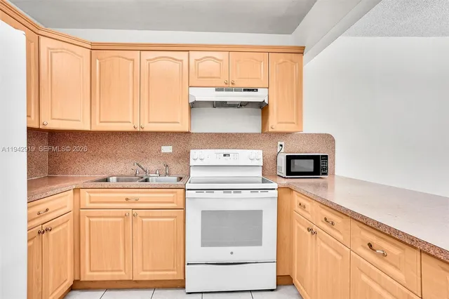 a kitchen with granite countertop white cabinets and white appliances