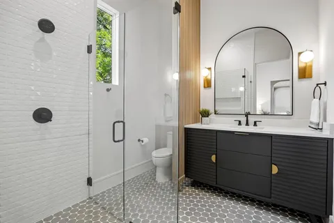 a bathroom with a double vanity sink toilet and shower