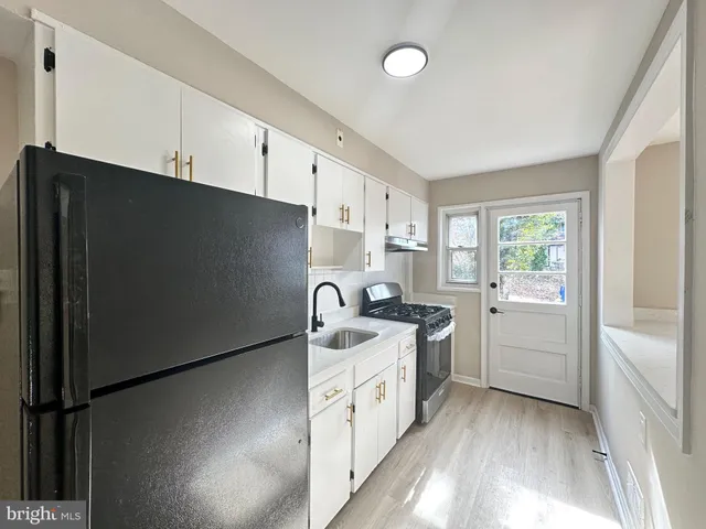 a kitchen with a sink a stove and cabinets