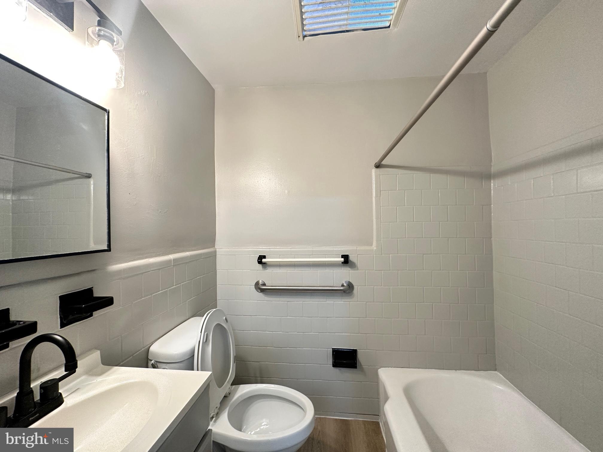 1038 Wedgewood Road Baltimore, MD 21229 - Photo 7 of 12 a bathroom with a toilet a sink and bathtub
