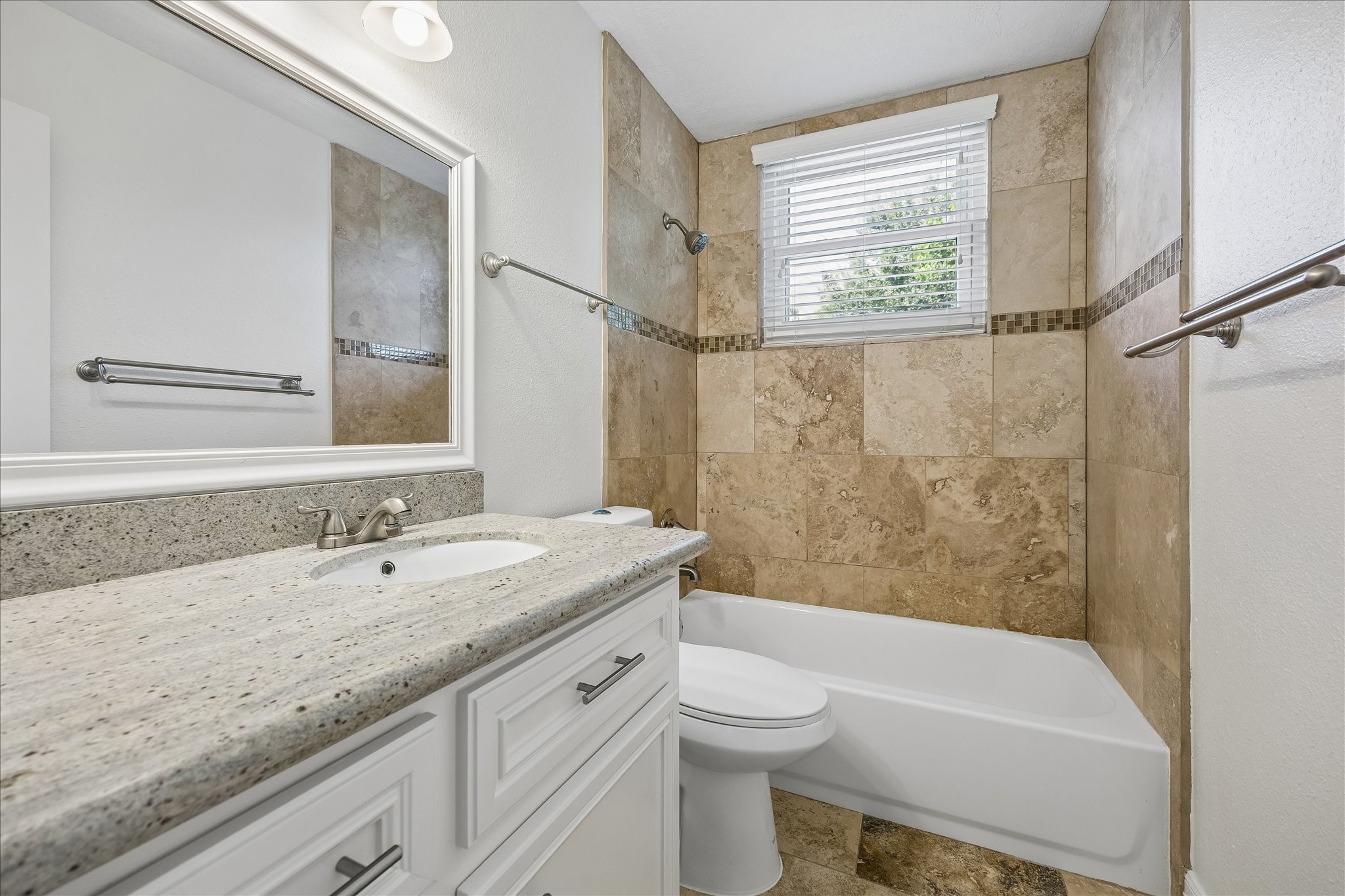 5019 Kinglet Street Houston, TX 77035 - Photo 19 of 24 Third full bath (rare find!) features granite counters with undermount sink, upgraded cabinetry, framed mirror, beautiful travertine bath surround, plus upgraded fixtures & hardware!