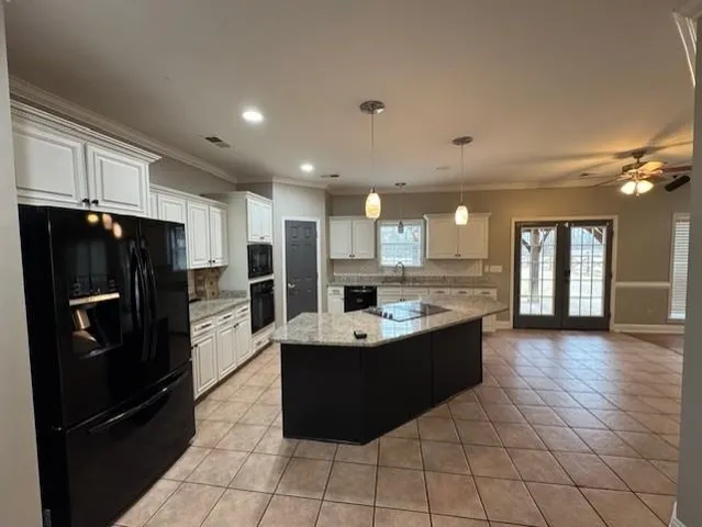 a kitchen with stainless steel appliances granite countertop a sink and a refrigerator