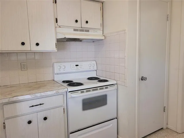 a kitchen with white cabinets and white appliances
