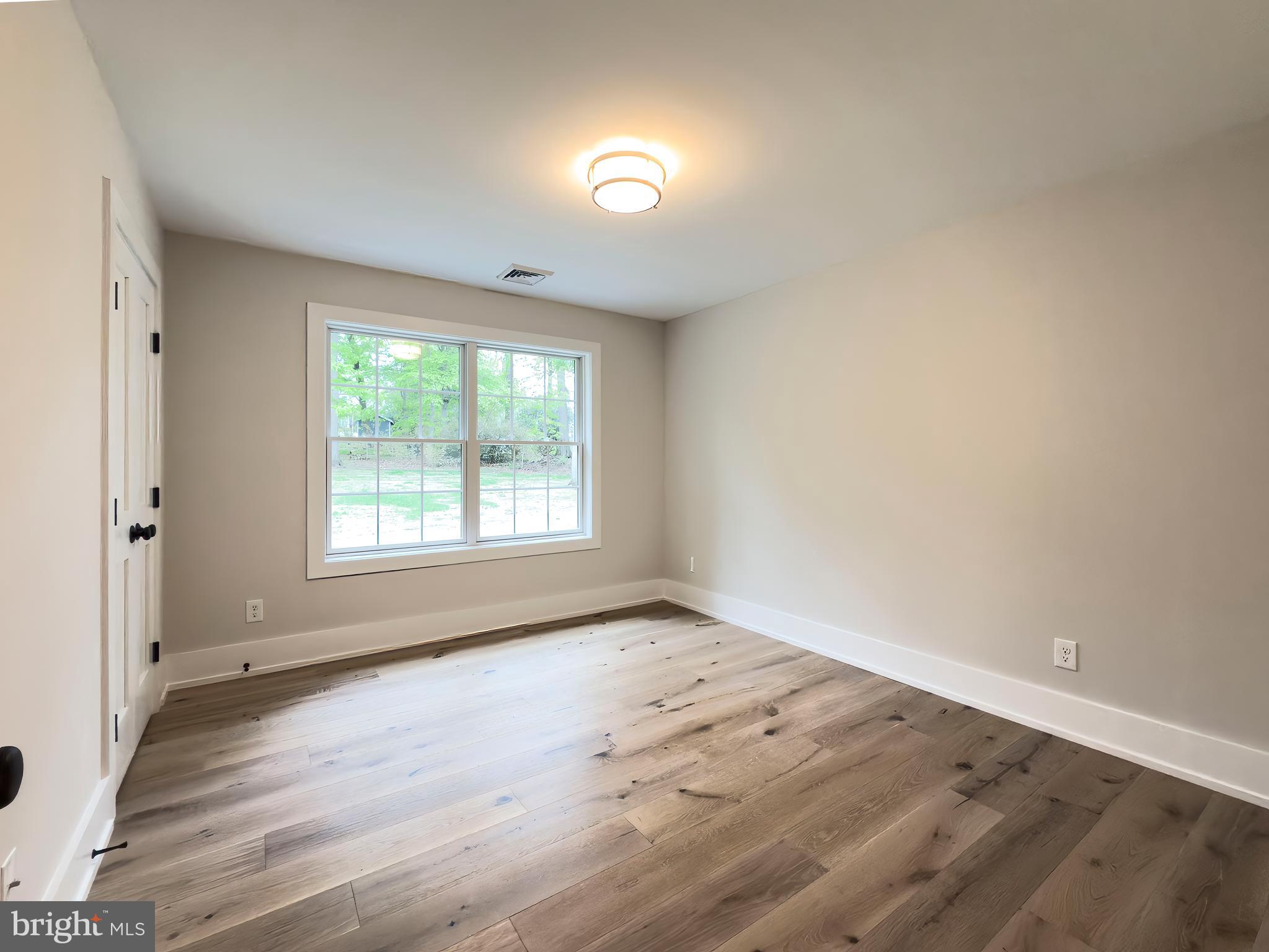 665 Valley View Lane Wayne, PA 19087 - Photo 26 of 34 an empty room with wooden floor and windows