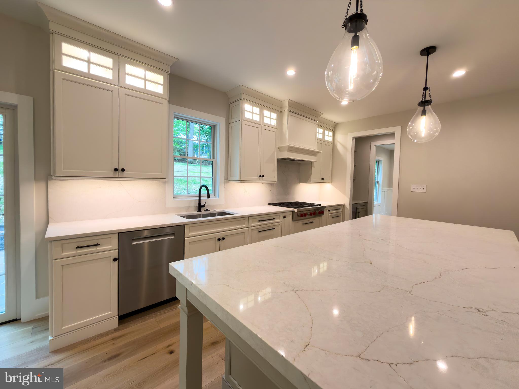 665 Valley View Lane Wayne, PA 19087 - Photo 9 of 34 a kitchen with a stove a sink a center island and cabinets