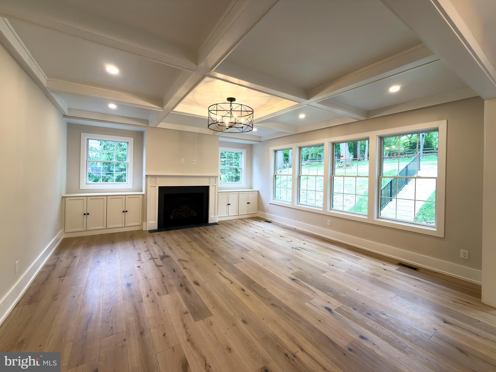 665 Valley View Lane Wayne, PA 19087 - Photo 10 of 34 an empty room with windows fireplace and wooden floor