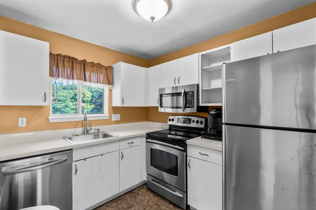 a kitchen with stainless steel appliances a refrigerator sink and microwave