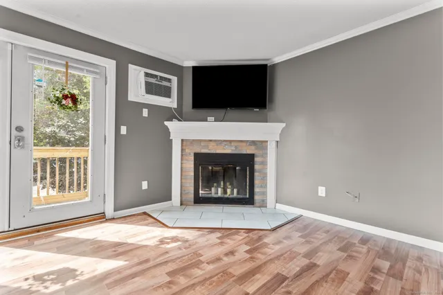 a view of an empty room with a fireplace and a window