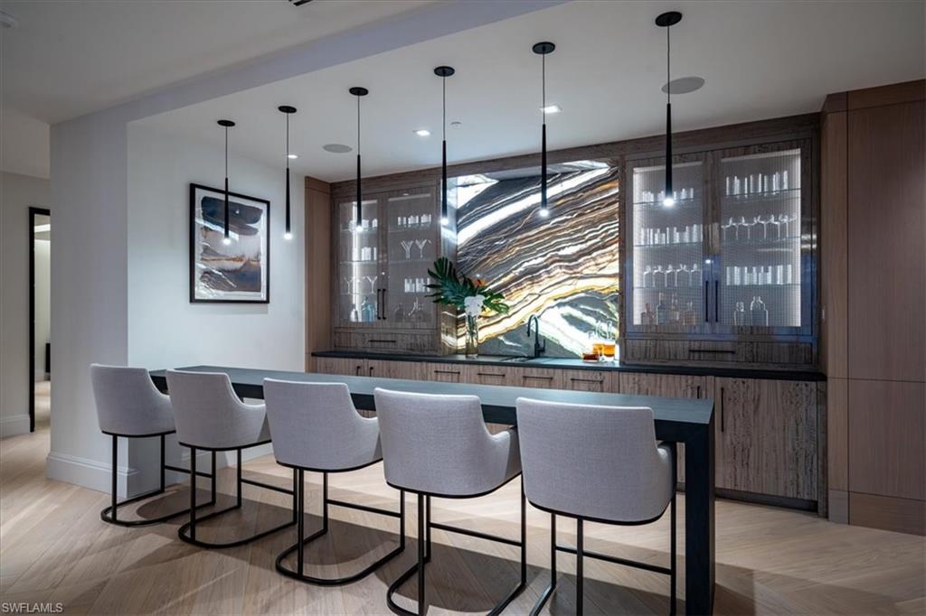 81 Seagate Drive, Unit PH20 Naples, FL 34103 - Photo 31 of 46 a kitchen with a refrigerator a sink and chairs