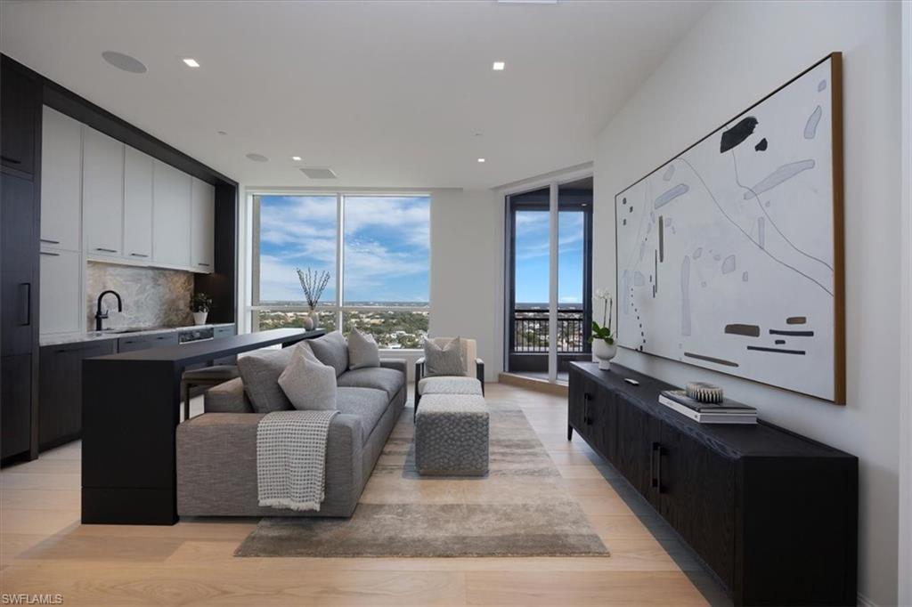 81 Seagate Drive, Unit PH20 Naples, FL 34103 - Photo 37 of 46 a living room with furniture and a large window