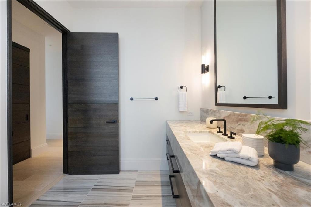 81 Seagate Drive, Unit PH20 Naples, FL 34103 - Photo 40 of 46 a bathroom with a sink and a mirror