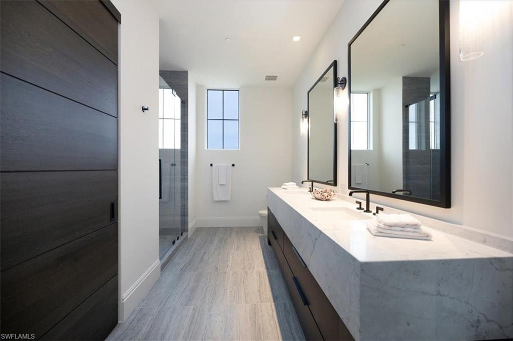 81 Seagate Drive, Unit PH20 Naples, FL 34103 - Photo 44 of 46 a bathroom with a double vanity sink and mirror