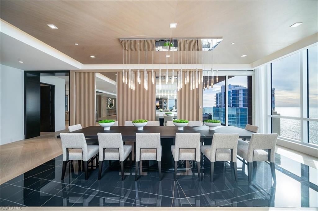 81 Seagate Drive, Unit PH20 Naples, FL 34103 - Photo 9 of 46 a view of a dining room with furniture window and wooden floor