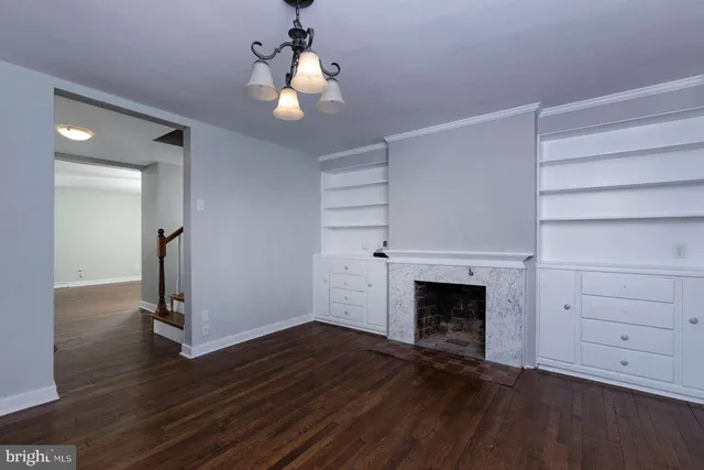 a view of empty room with wooden floor and ceiling fan