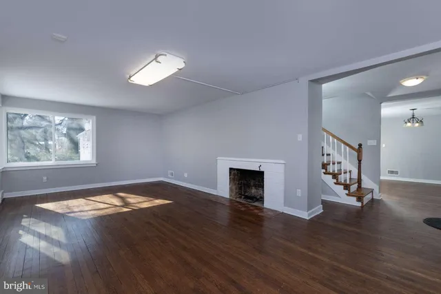 a view of empty room with wooden floor and window