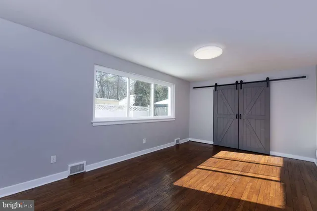 a view of a room with wooden floor and windows