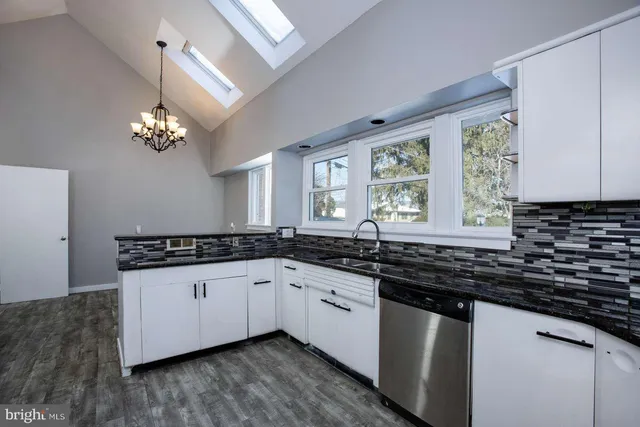 a kitchen with granite countertop a sink and a stove