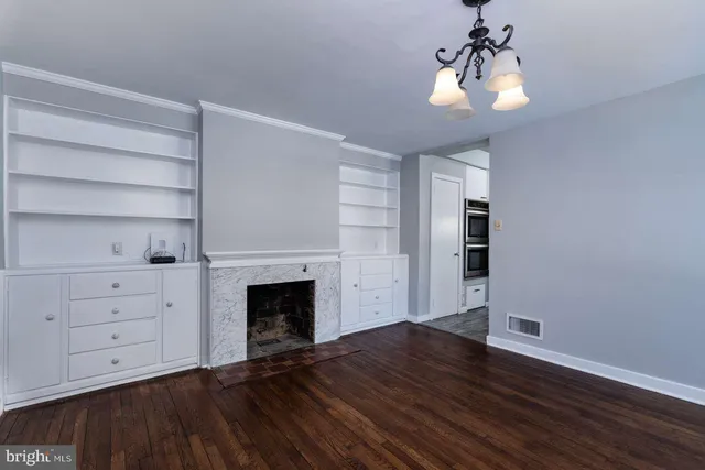 a view of an empty room with a fireplace and a window