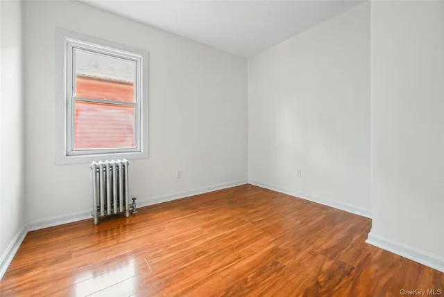 an empty room with wooden floor and a window