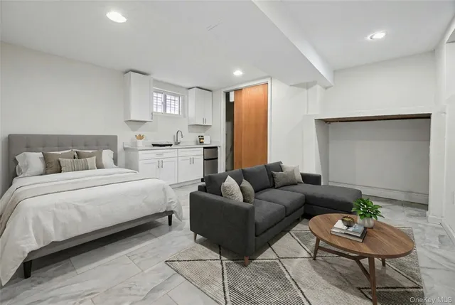 a spacious bedroom with a bed a couch and a potted plant on table