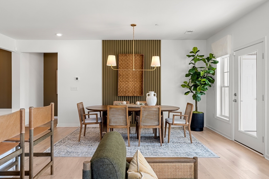 2 Codman Way, Unit 307 Westborough, MA 01581 - Photo 14 of 41 a dining room with furniture potted plants and wooden floor